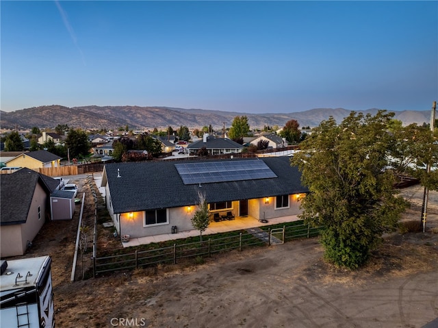 view of front of property featuring a mountain view and solar panels