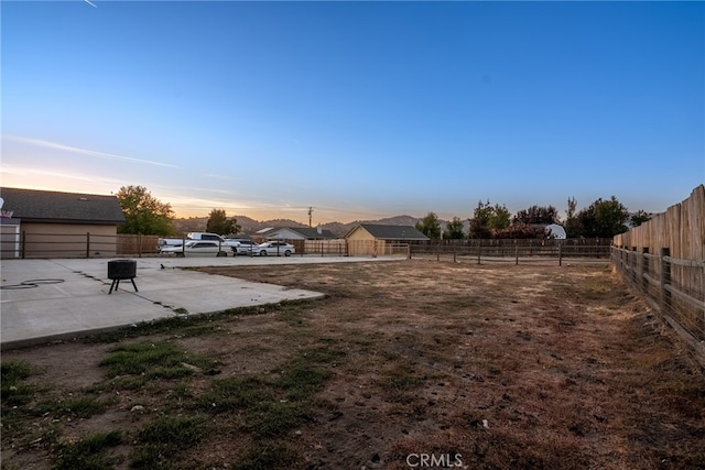 yard at dusk featuring a patio area