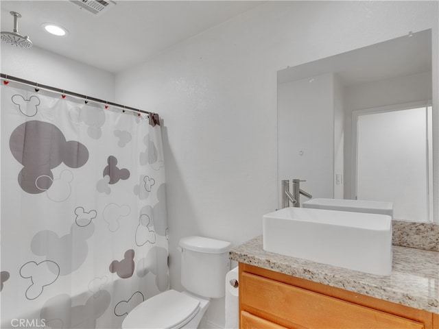 bathroom featuring vanity, toilet, and walk in shower