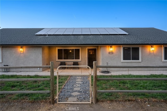 view of front of house featuring a patio and solar panels