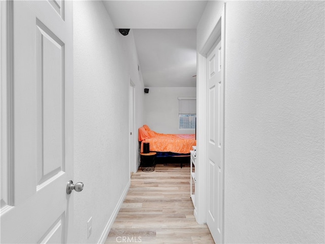 hallway with light hardwood / wood-style floors