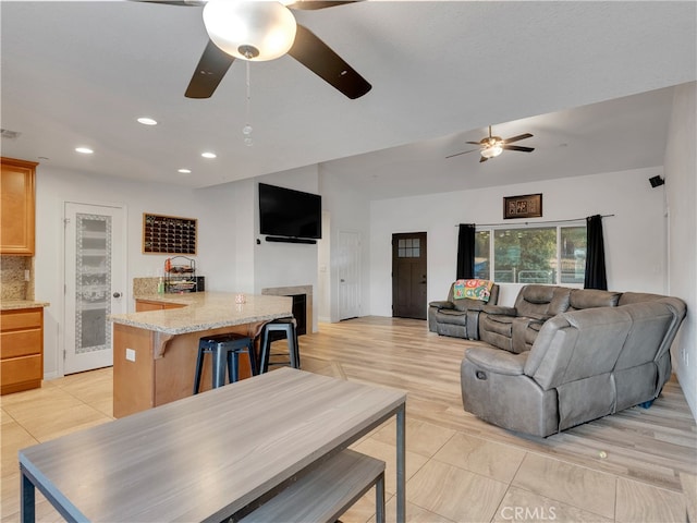 living room featuring light wood-type flooring and ceiling fan