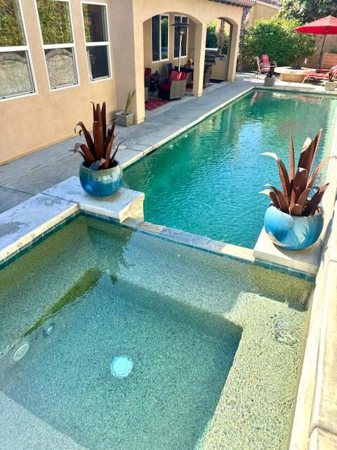 view of pool featuring an in ground hot tub and a patio