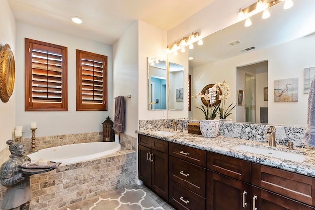 bathroom with vanity and tiled bath