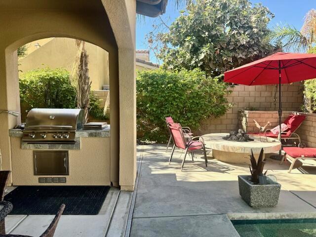 view of patio with a fire pit, area for grilling, and grilling area