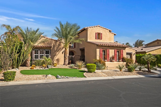 mediterranean / spanish-style home with a front lawn and a garage