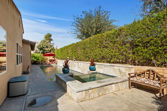 view of patio / terrace featuring an in ground hot tub