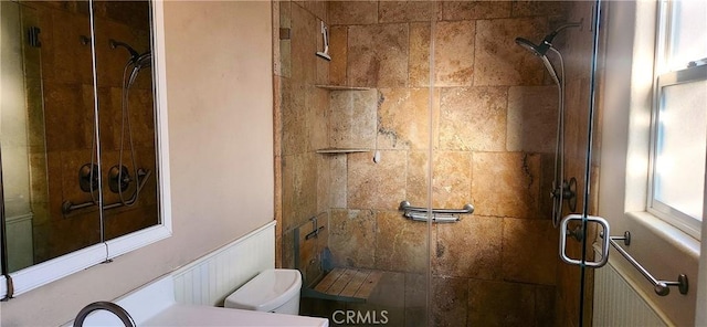 bathroom featuring a shower with shower door and toilet