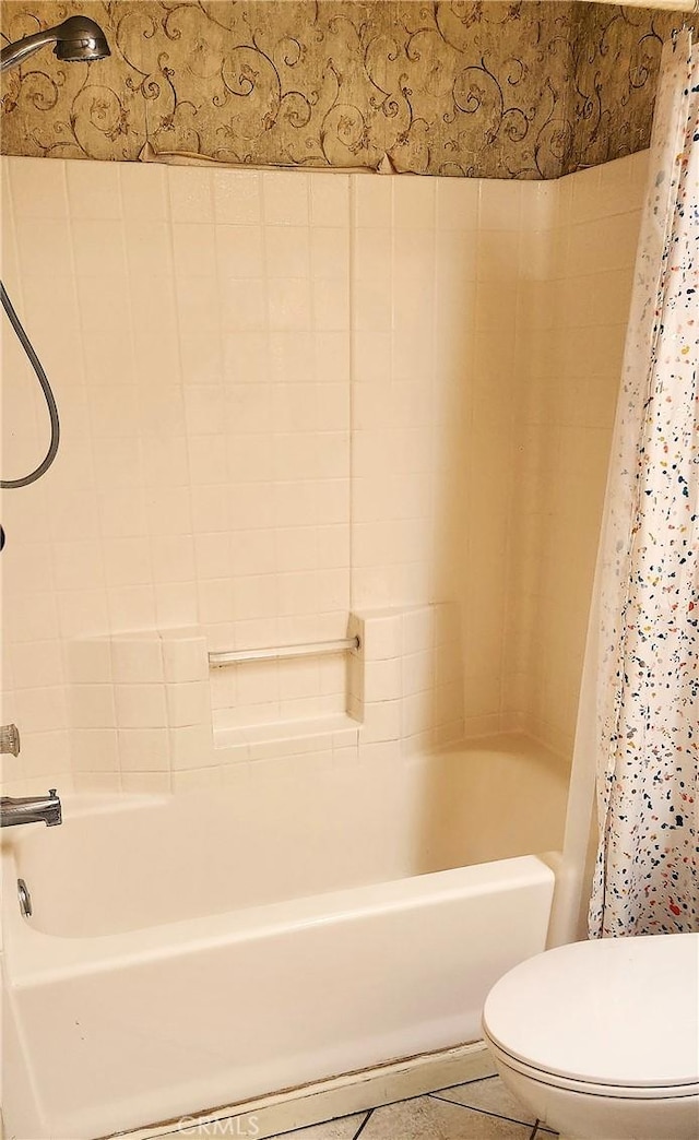 bathroom featuring tile patterned flooring, shower / tub combo with curtain, and toilet