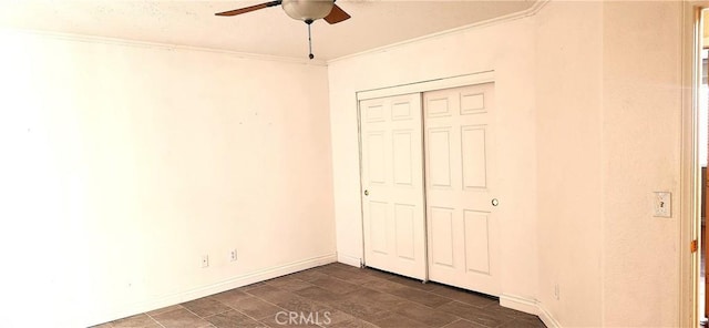 unfurnished bedroom with a closet, ceiling fan, crown molding, and dark wood-type flooring