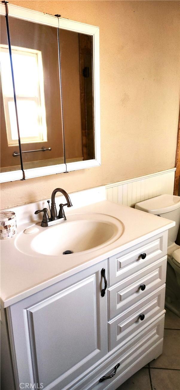 bathroom featuring tile patterned floors, vanity, and toilet