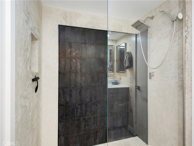 bathroom featuring vanity and tiled shower