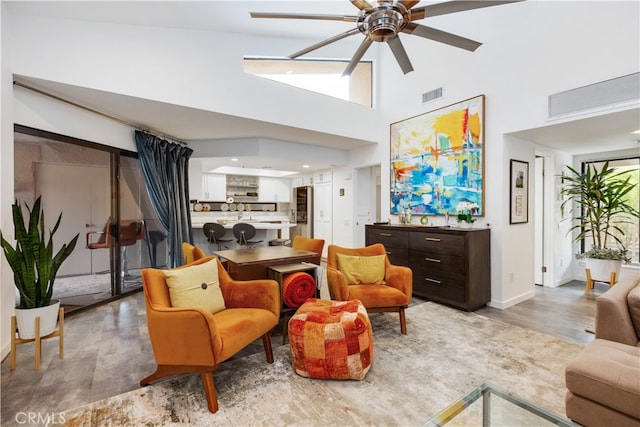 living room featuring hardwood / wood-style flooring, high vaulted ceiling, and ceiling fan