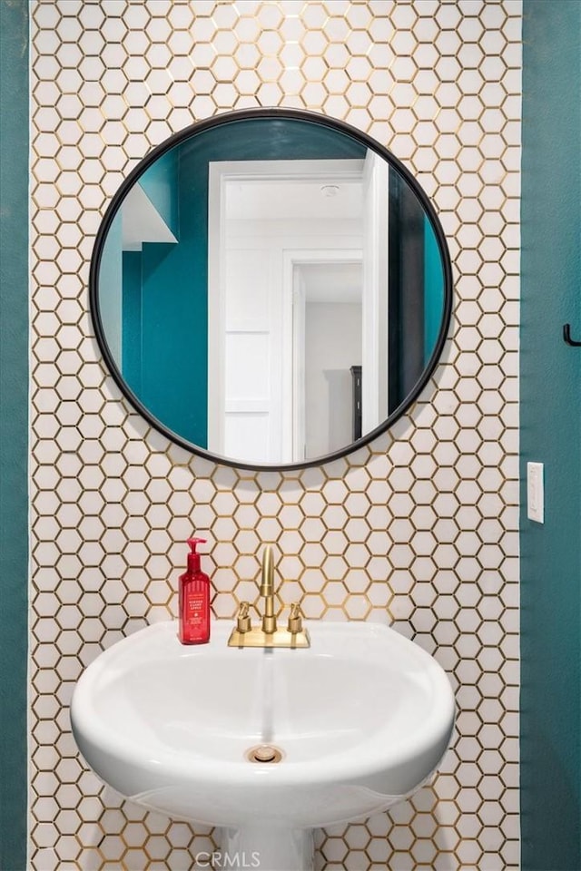 bathroom with sink and tasteful backsplash