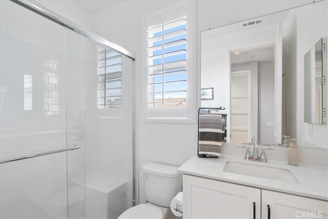 bathroom with vanity, toilet, and an enclosed shower