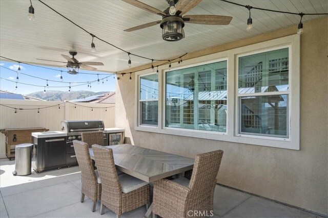 view of patio with a mountain view, a jacuzzi, and ceiling fan