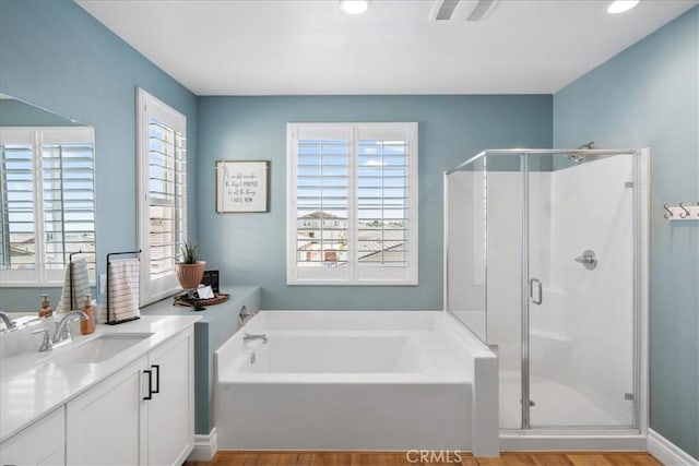 bathroom featuring hardwood / wood-style floors, vanity, and shower with separate bathtub