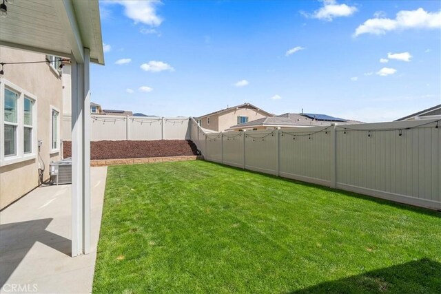 view of yard with central air condition unit and a patio