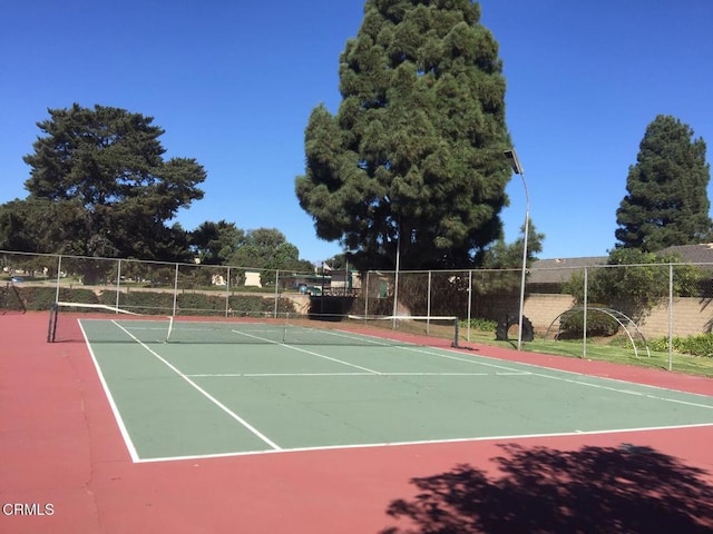 view of tennis court with basketball hoop