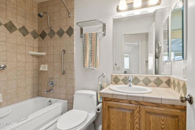 full bathroom with vanity, tiled shower / bath combo, and toilet