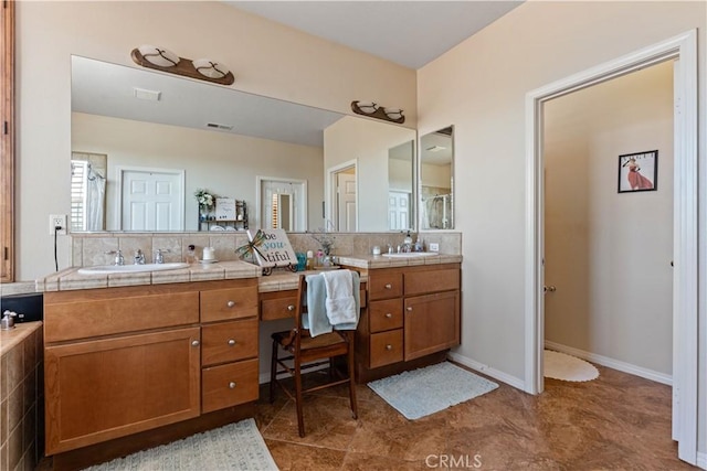 bathroom featuring decorative backsplash, vanity, and tile patterned flooring