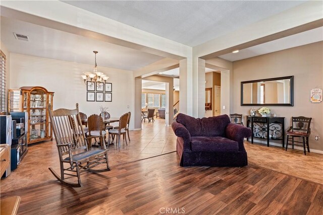 living room with hardwood / wood-style floors and a notable chandelier