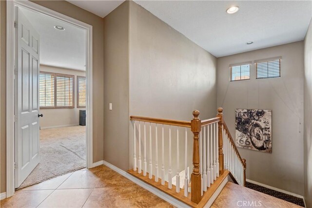 staircase with tile patterned flooring and a healthy amount of sunlight