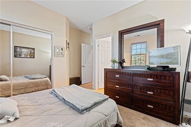 bedroom featuring light colored carpet and a closet