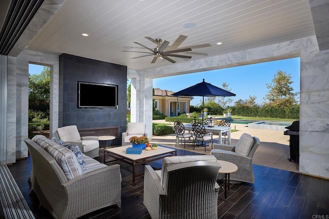 view of patio / terrace featuring an outdoor living space with a fireplace and ceiling fan