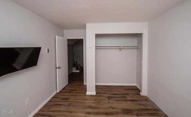 unfurnished bedroom with a closet and dark hardwood / wood-style flooring