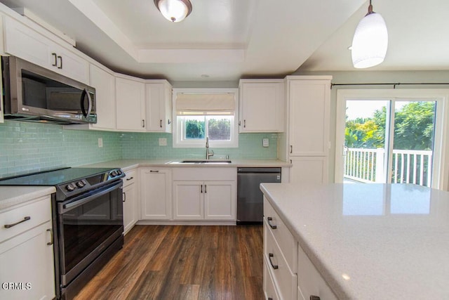 kitchen featuring sink, pendant lighting, white cabinets, and stainless steel appliances