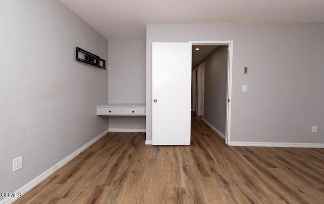 unfurnished bedroom with dark hardwood / wood-style flooring