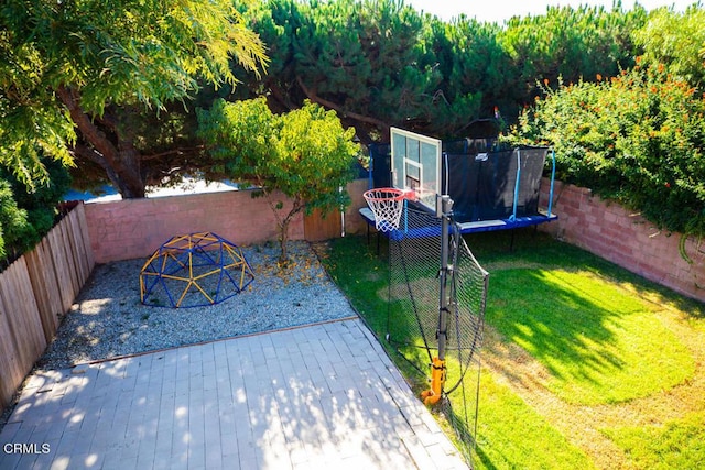 view of yard with a trampoline and a deck