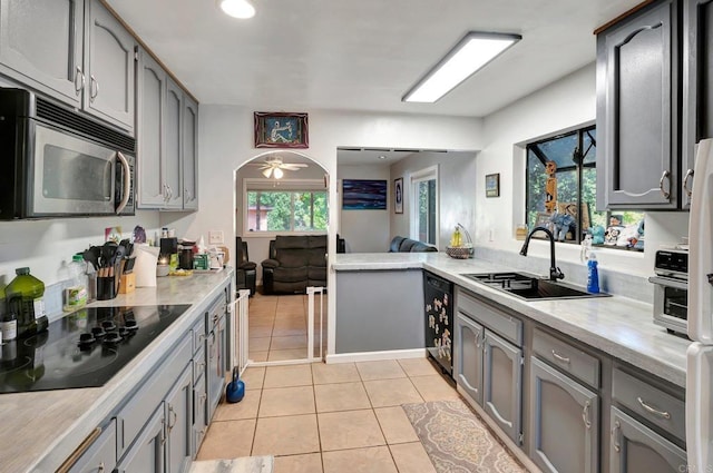 kitchen featuring ceiling fan, sink, black appliances, light tile patterned floors, and gray cabinets