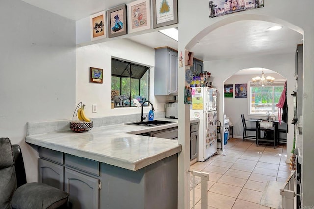 kitchen with gray cabinetry, sink, a healthy amount of sunlight, and white refrigerator