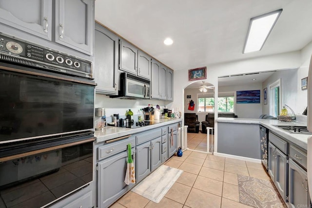 kitchen with light tile patterned floors, gray cabinetry, and black appliances