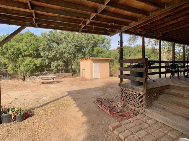 view of patio with a storage shed and a deck