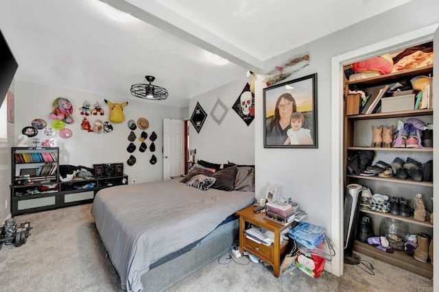 bedroom with beamed ceiling and light colored carpet