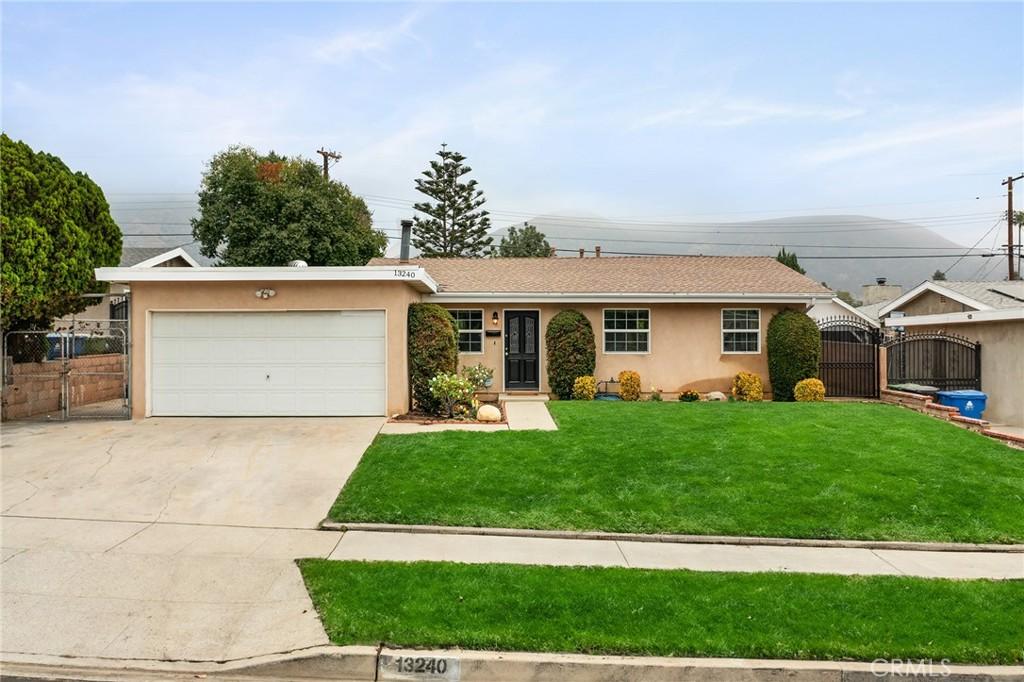 single story home with a garage and a front lawn