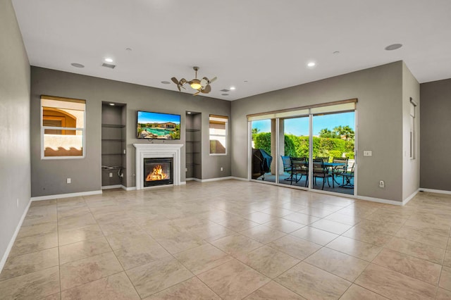 unfurnished living room with ceiling fan, light tile patterned floors, and a wealth of natural light