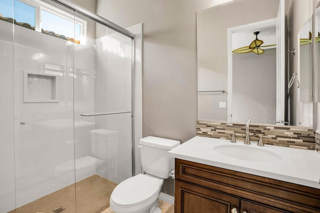 bathroom with toilet, an enclosed shower, tasteful backsplash, and vanity