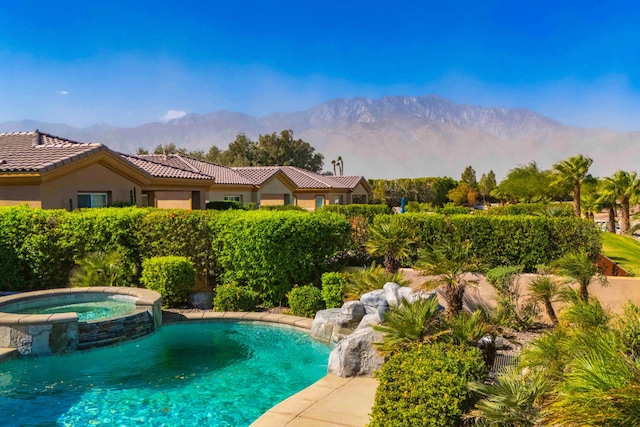 view of pool with a mountain view, pool water feature, and an in ground hot tub