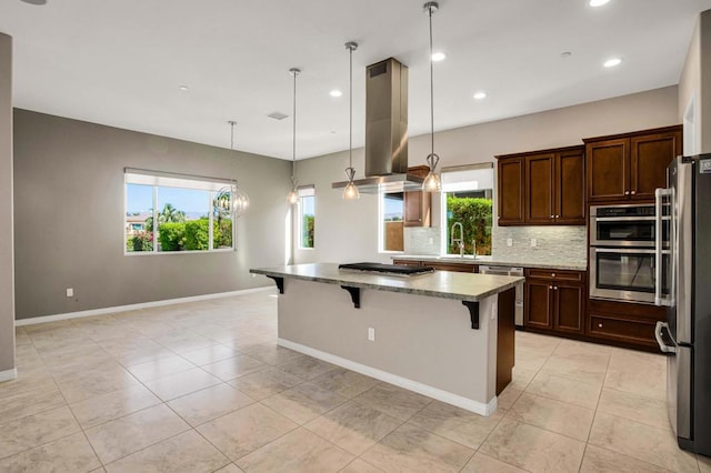 kitchen featuring a kitchen breakfast bar, a healthy amount of sunlight, stainless steel appliances, and island range hood