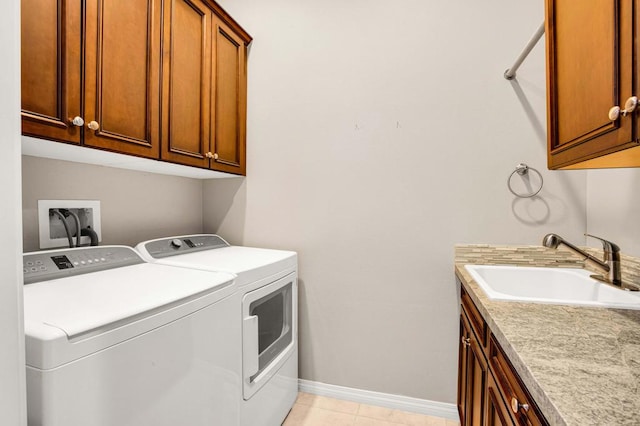 laundry room with cabinets, washer and dryer, sink, and light tile patterned floors