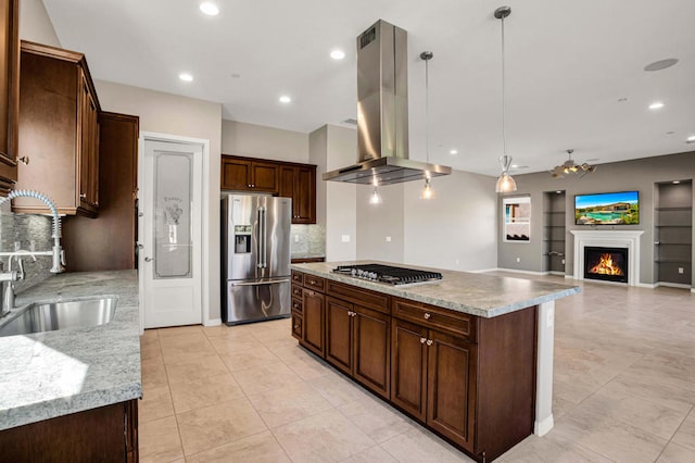 kitchen with island exhaust hood, a kitchen island, sink, decorative light fixtures, and appliances with stainless steel finishes