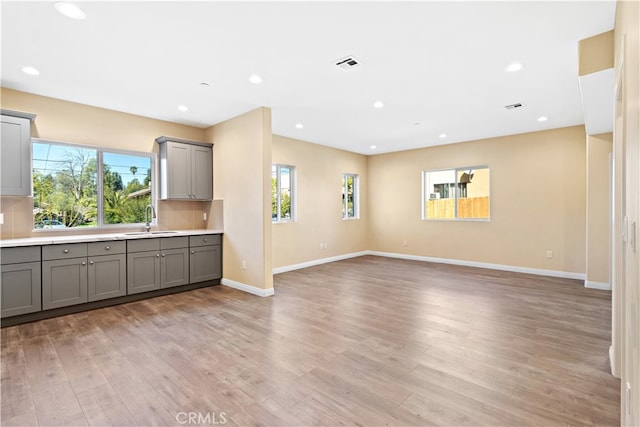 unfurnished living room with sink and light wood-type flooring