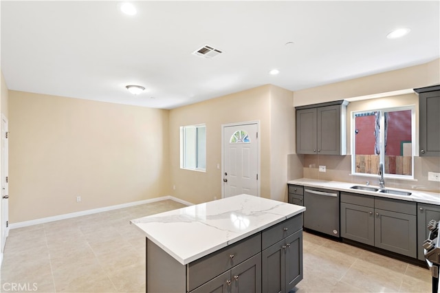 kitchen featuring a healthy amount of sunlight, sink, stainless steel dishwasher, and a kitchen island