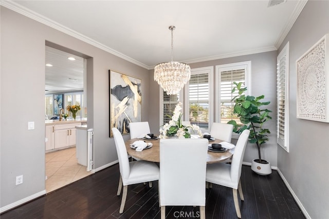 dining room featuring light wood-type flooring, crown molding, and a chandelier