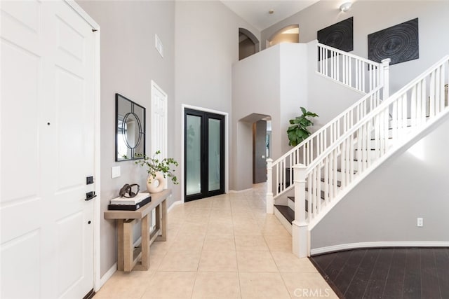 entryway with light tile patterned flooring and a high ceiling