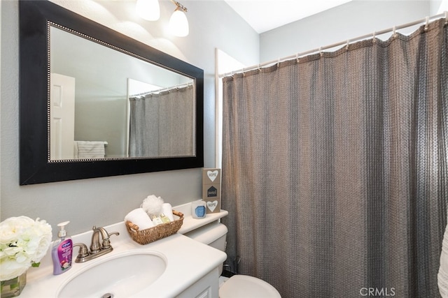 bathroom with toilet, a shower with shower curtain, and vanity